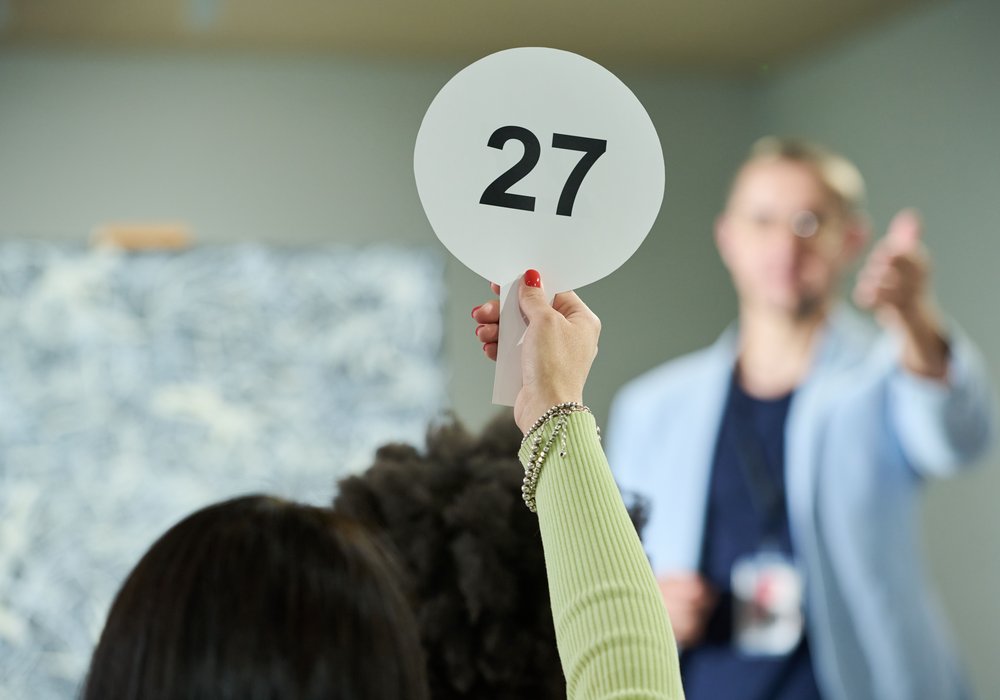 A bidder raising paddle 27 in the saleroom