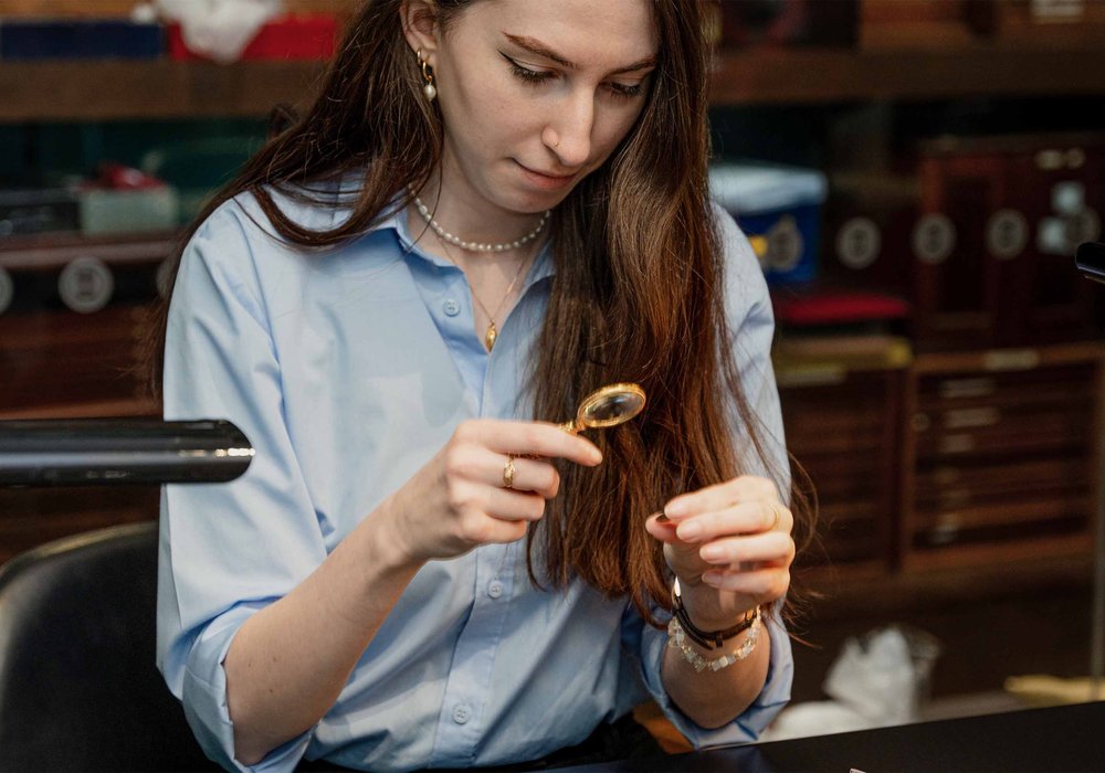 A specialist examining a coin with a loupe